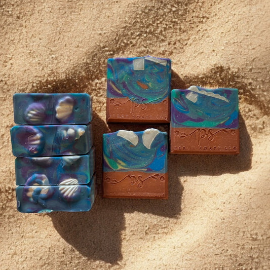 blue swirl soap with seashells sitting on a light brown base