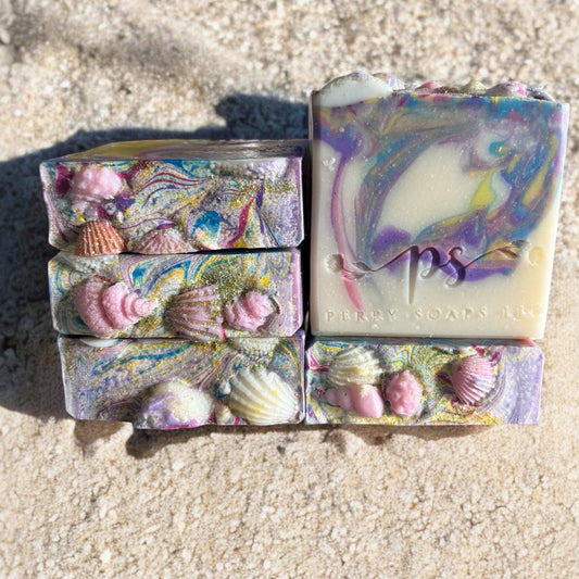 square soap bar with swirls of pastel colors and sea shells embedded on top