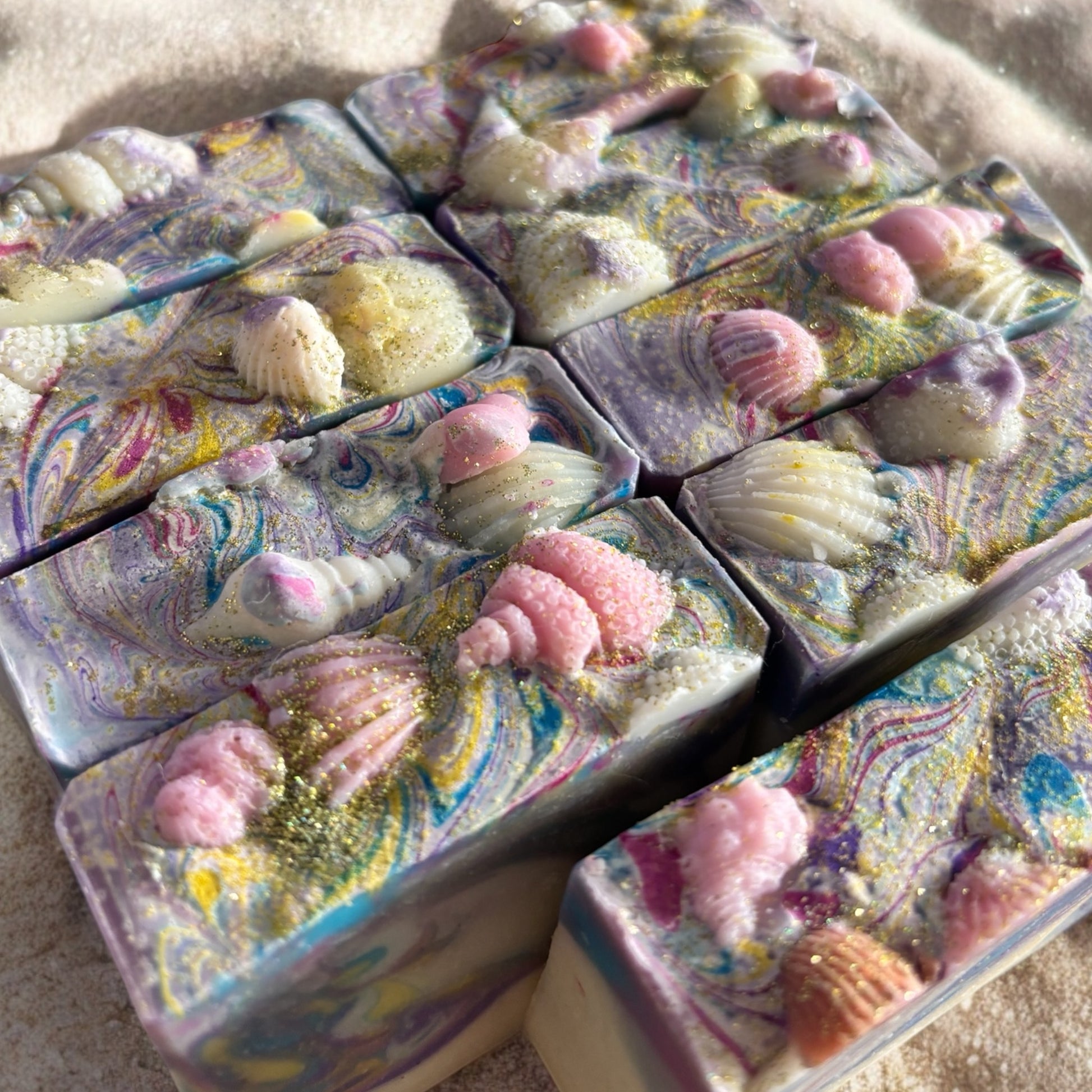 square soap bar with swirls of pastel colors and sea shells embedded on top